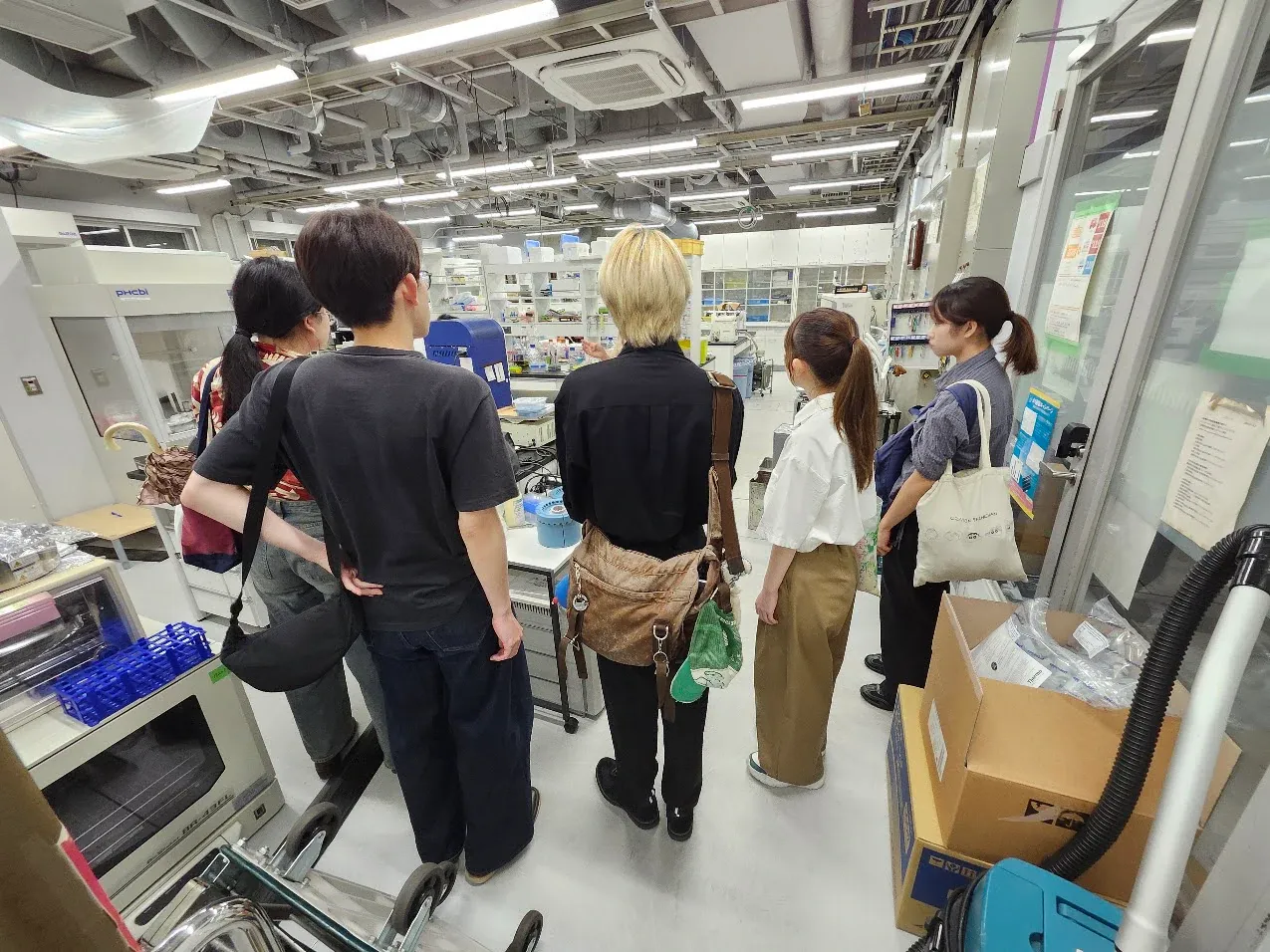 京都大学の実験施設を見学する学生たち