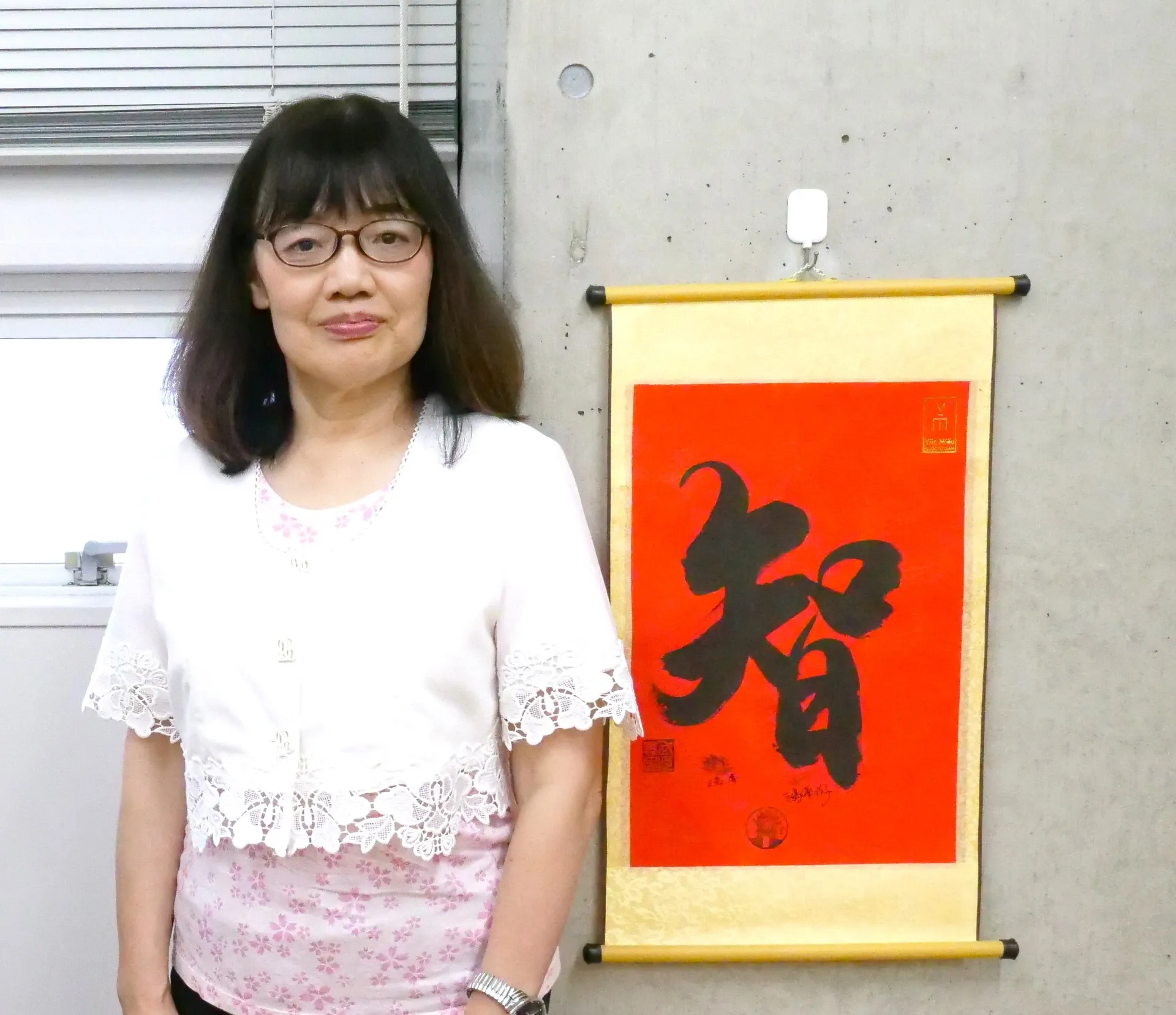掛け軸の前に立つ原浩子先生