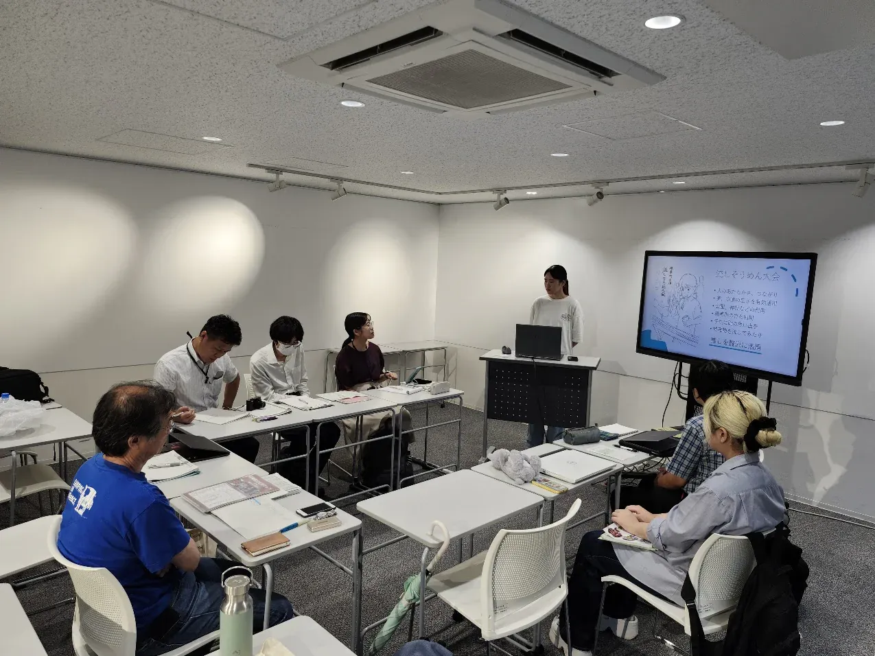 中間発表会で学生が精華町の企画を説明する様子